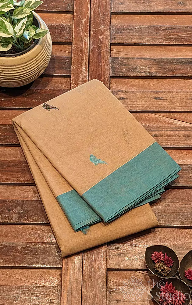 Beige kanchi cotton saree adorned with parrot motifs