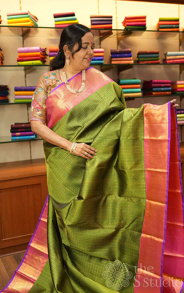 Green kanjivaram silk saree with peachish pink korvai border