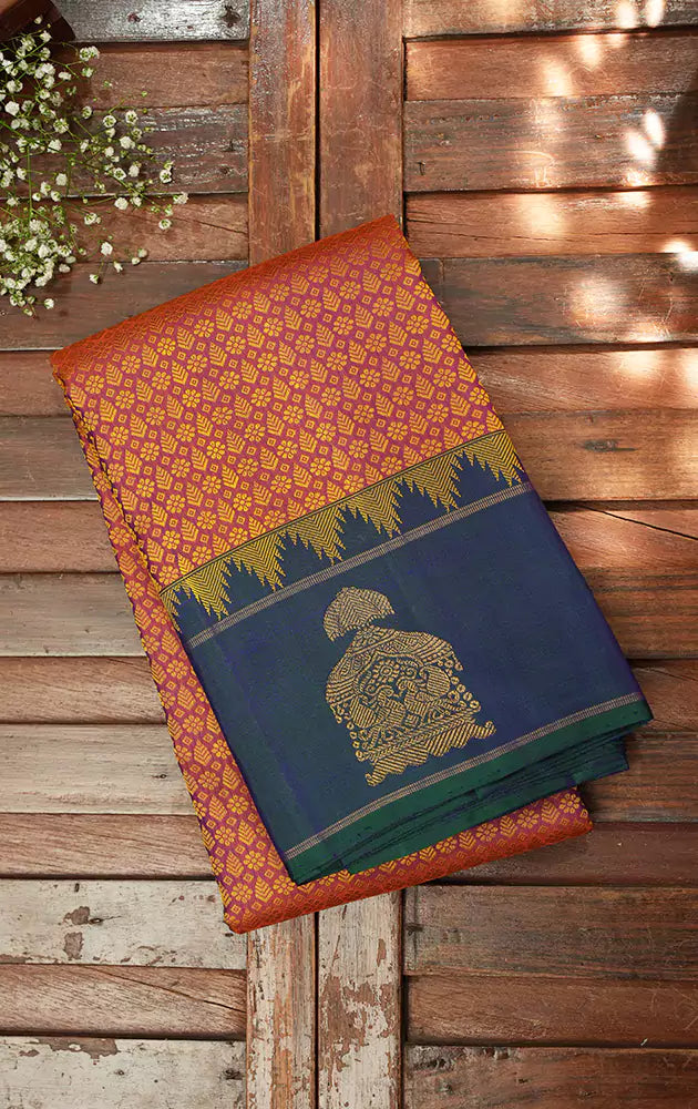 Peachish orange kanjivaram silk saree with a peacock blue border