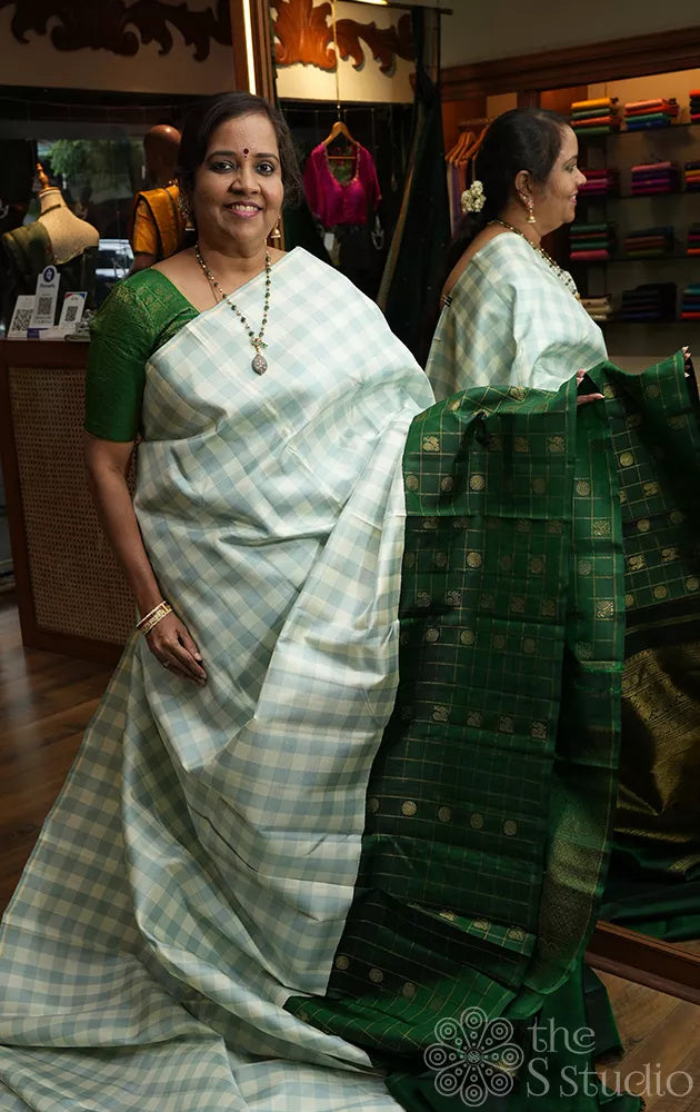 White and pastel green checked kanchi silk saree with bottle green long border