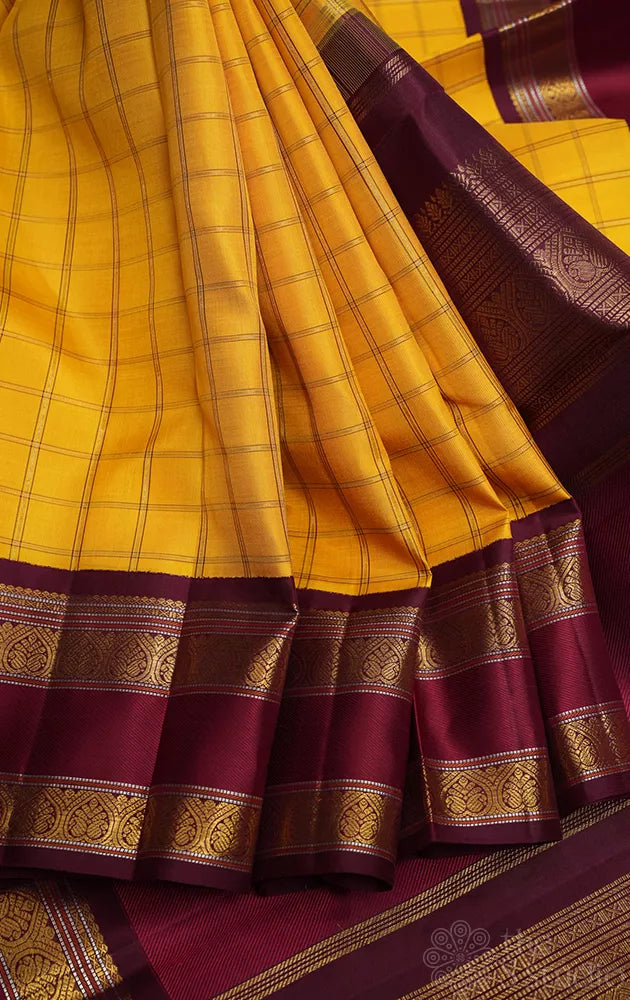 Yellow kanjivaram silk saree with zari checks and korvai brown border