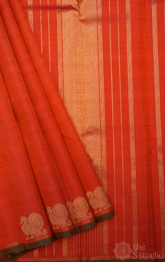 Rust orange kanchi silk saree with peacock motifs along the border