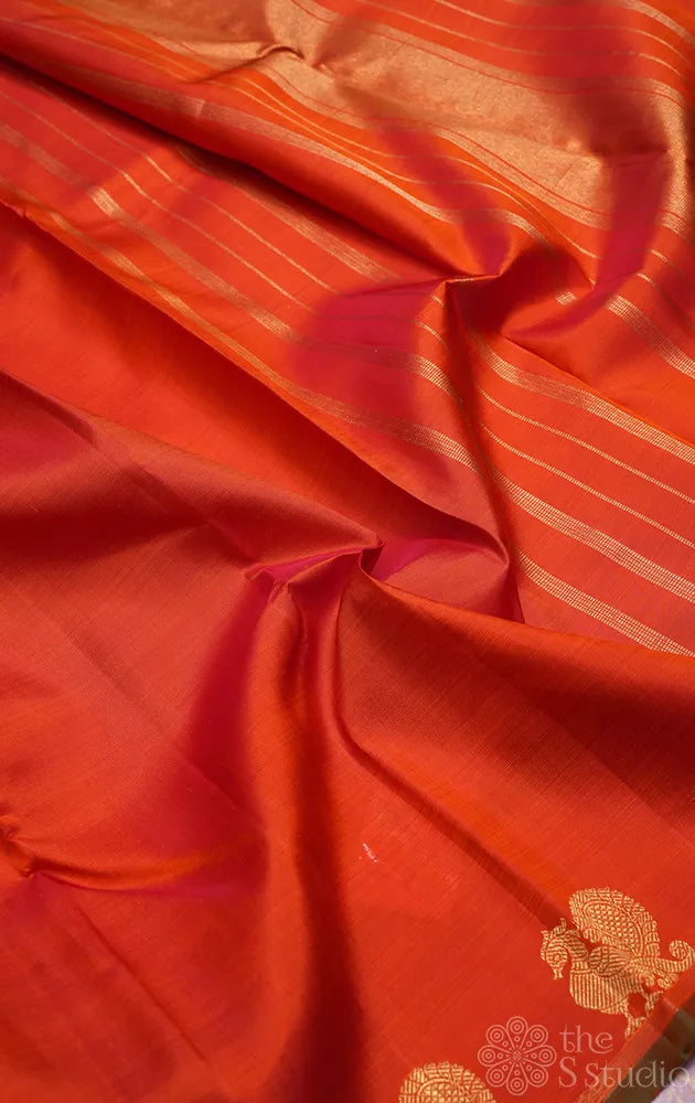 Rust orange kanchi silk saree with peacock motifs along the border