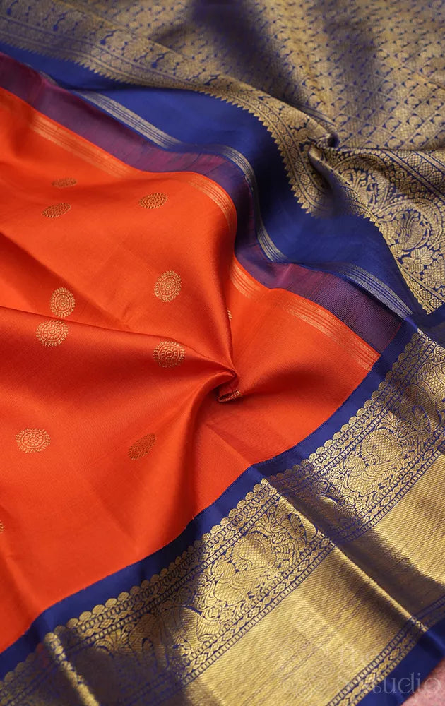 Rust orange kanchi pattu saree with navy blue korvai border