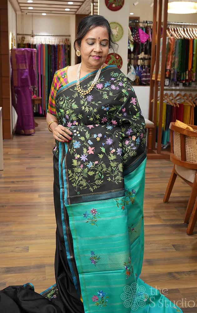 Black kanchipuram silk saree with floral hand painting and a sea green pallu