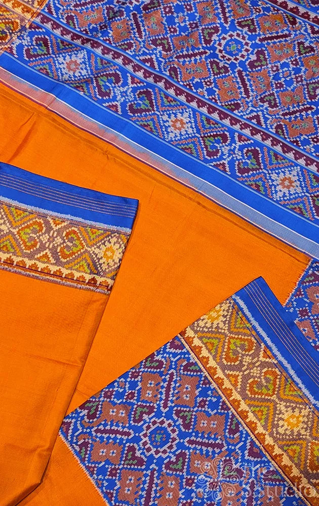 Orange patola silk saree with blue border in ikat design