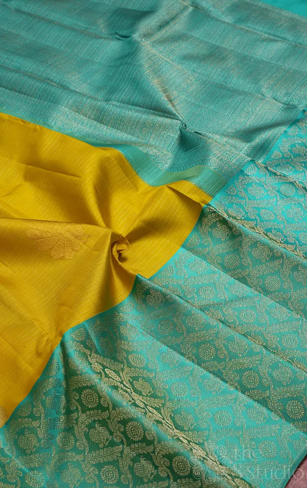 Yellow kanchi pattu saree with sea green zari woven long border