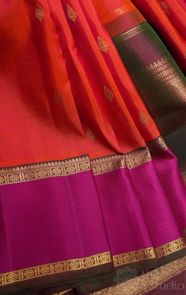 Bright orange kanchipuram silk saree with manthulir green border