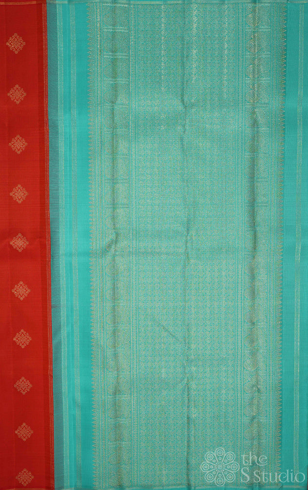 Orange kanjivaram silk saree with kolam buttas and sea green pallu