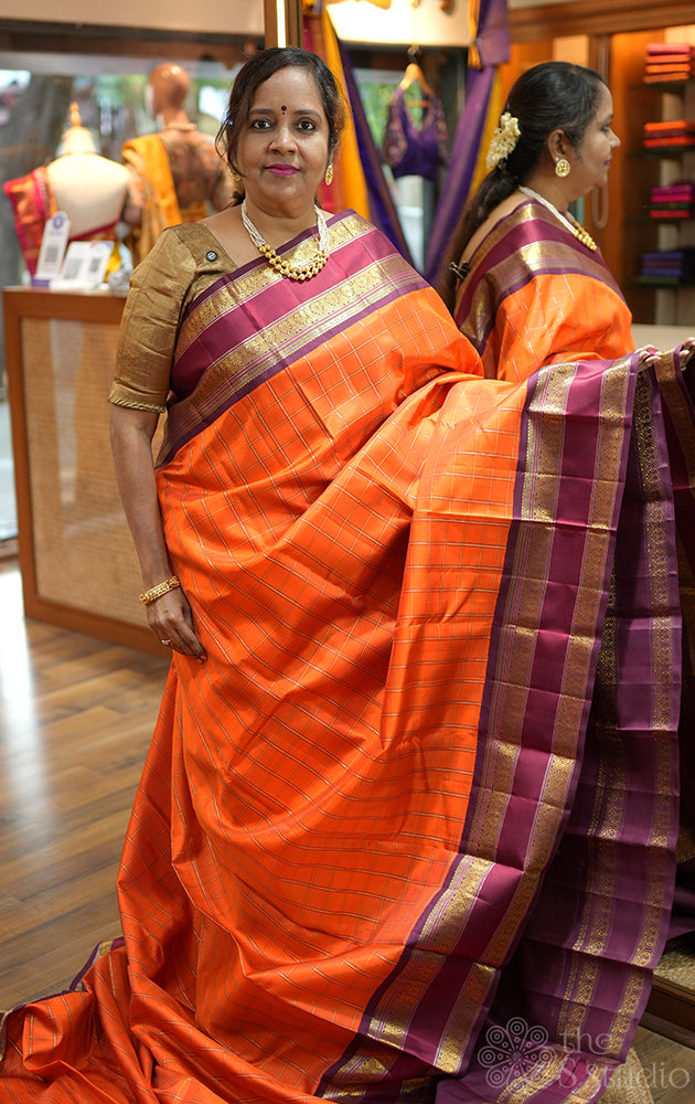 Orange kanjivaram silk saree with zari checks and korvai brown border