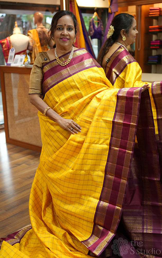Yellow kanjivaram silk saree with zari checks and korvai brown border