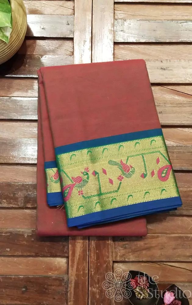 Brown kanchi cotton saree with blue selvedge and a zari border adorned with peacock motifs