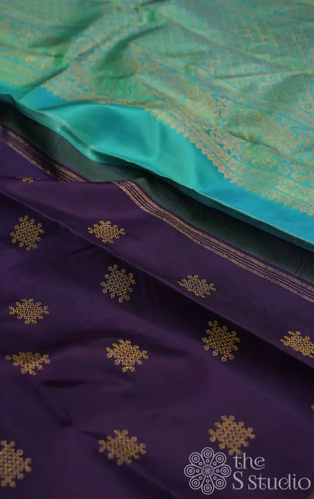 Deep violet colour kanjivaram saree with kolam buttas and sea green pallu