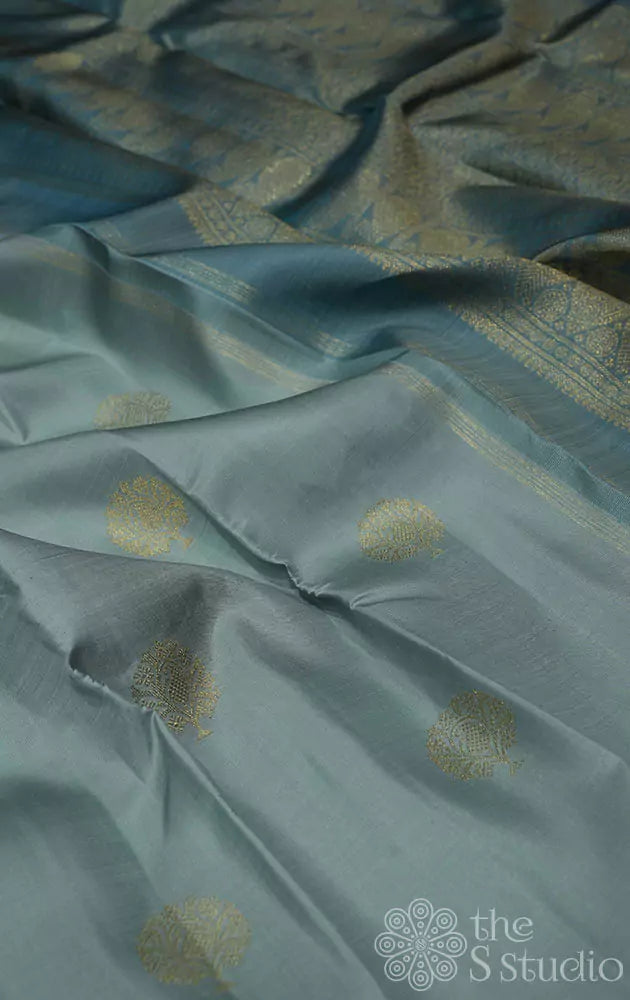 Teal grey kanjivaram saree with zari buttas and a teal blue pallu