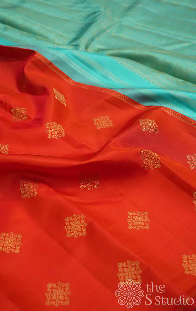 Orange kanjivaram silk saree with kolam buttas and sea green pallu