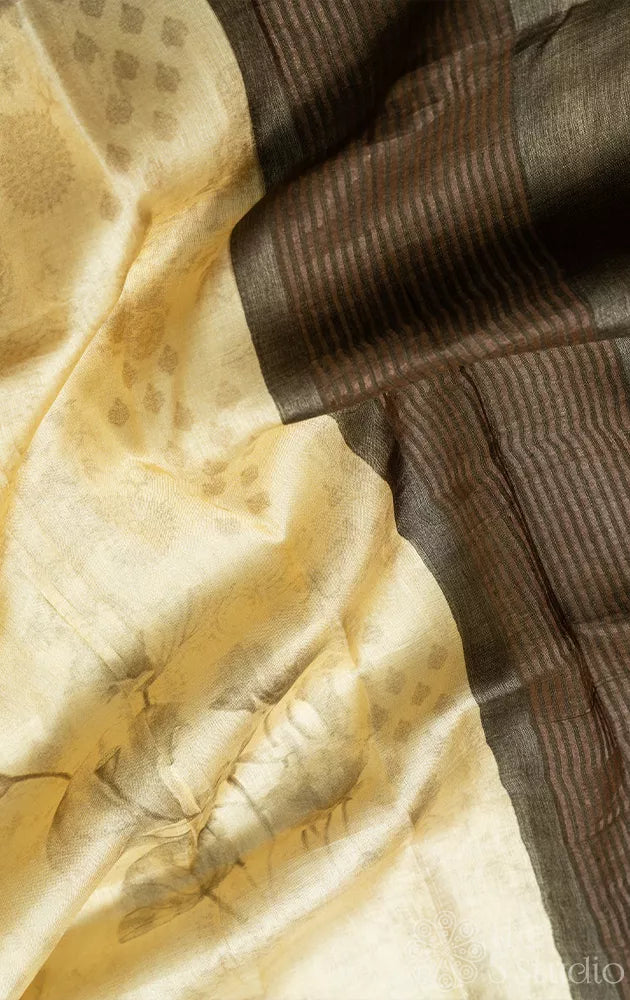 Light yellow tussar silk saree with floral prints and contrast pallu