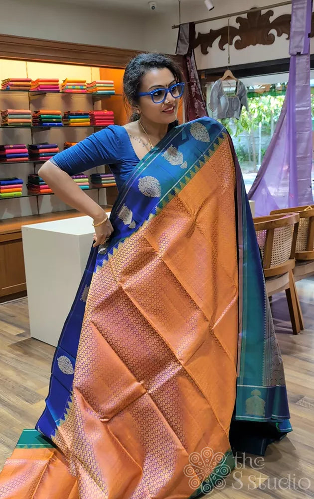Peachish orange kanjivaram silk saree with a peacock blue border