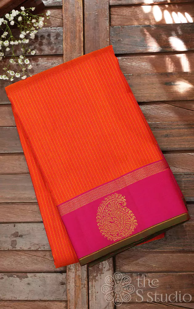 Orange kanchi silk saree with vertical thread lines and pink border