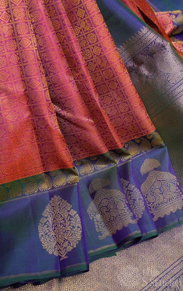 Peachish orange kanjivaram silk saree with a peacock blue border