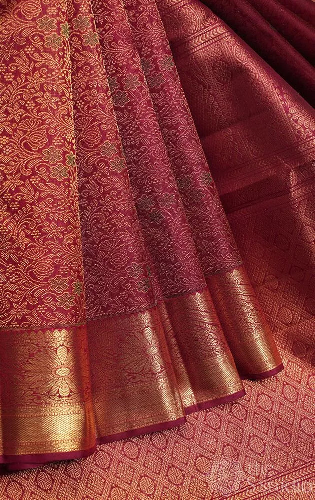 Maroon kanjivaram silk saree with all over floral meenakari motifs and grand border