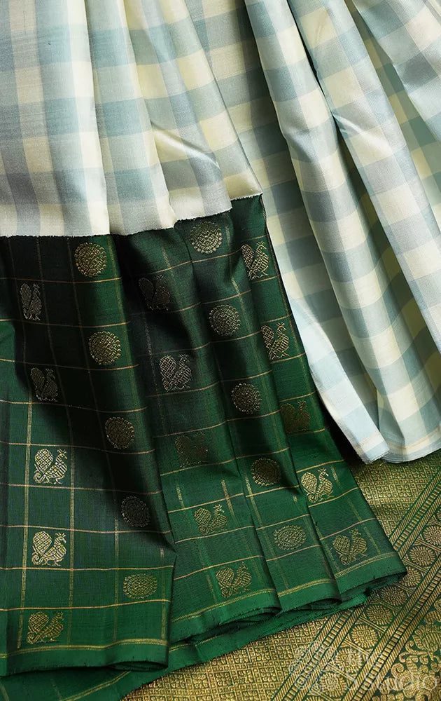 White and pastel green checked kanchi silk saree with bottle green long border