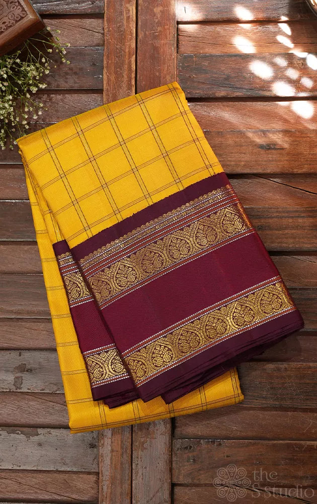 Yellow kanjivaram silk saree with zari checks and korvai brown border