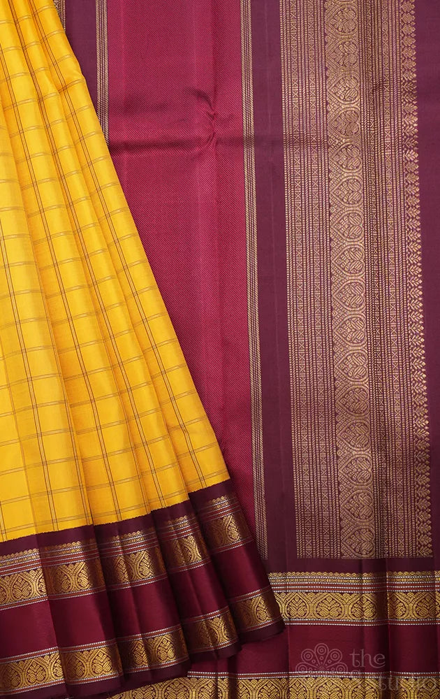 Yellow kanjivaram silk saree with zari checks and korvai brown border