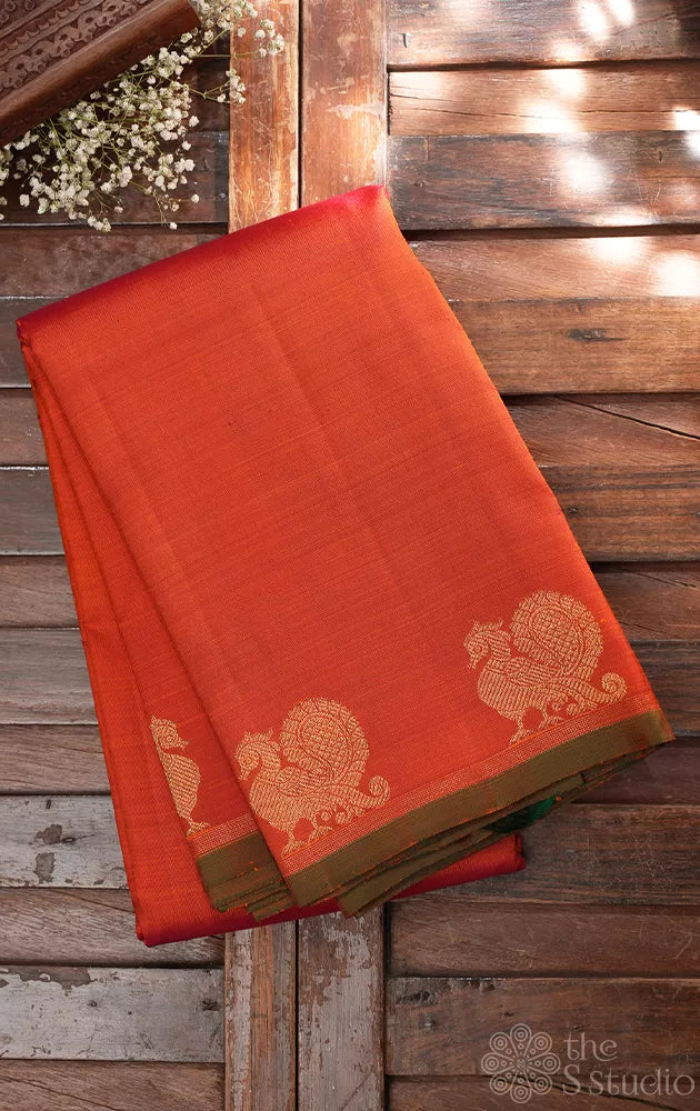 Rust orange kanchi silk saree with peacock motifs along the border