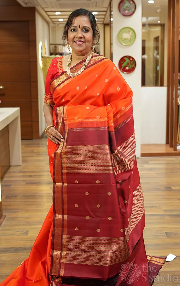 Bright orange kanjivaram silk saree with brown border