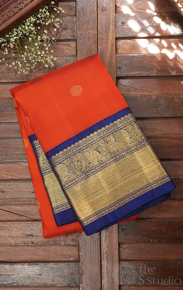 Rust orange kanchi pattu saree with navy blue korvai border