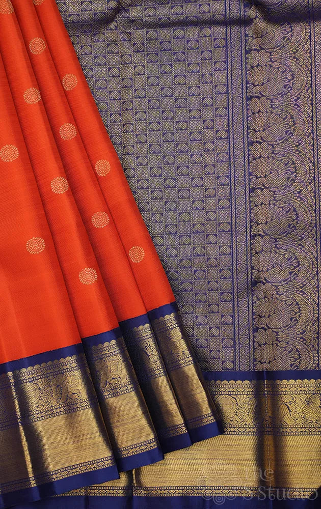 Rust orange kanchi pattu saree with navy blue korvai border