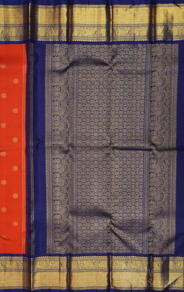 Rust orange kanchi pattu saree with navy blue korvai border