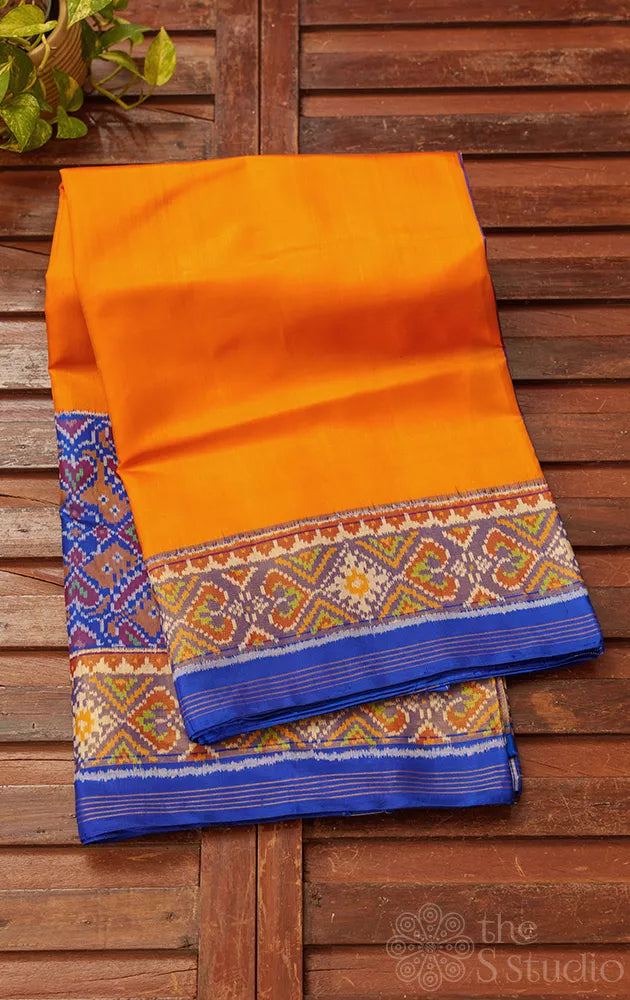 Orange patola silk saree with blue border in ikat design