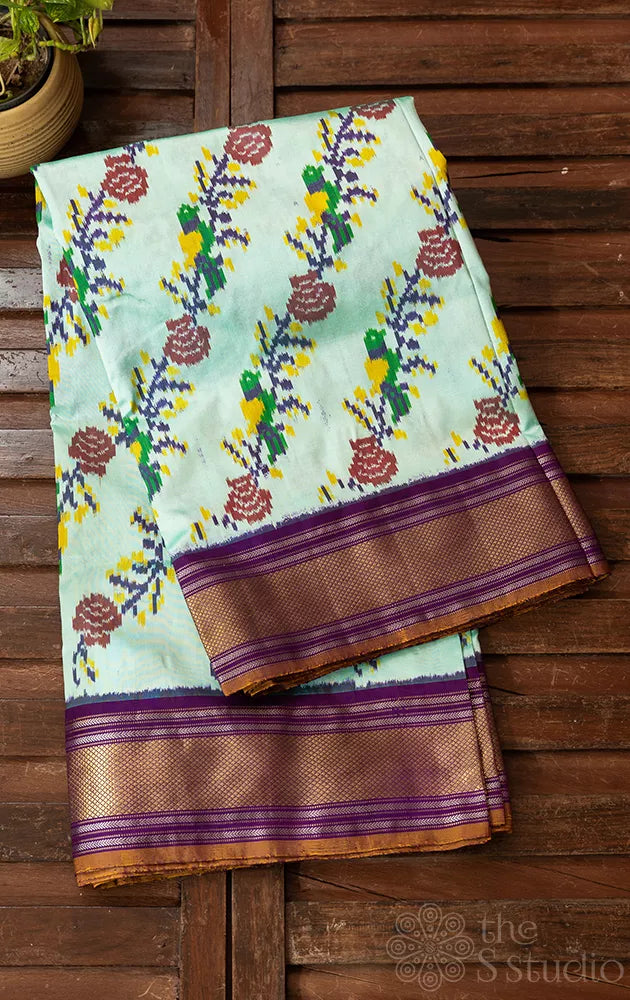 Pale green ikkat silk saree with contrast purple zari border