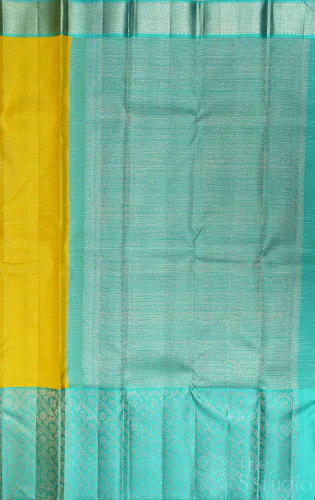 Yellow kanchi pattu saree with sea green zari woven long border