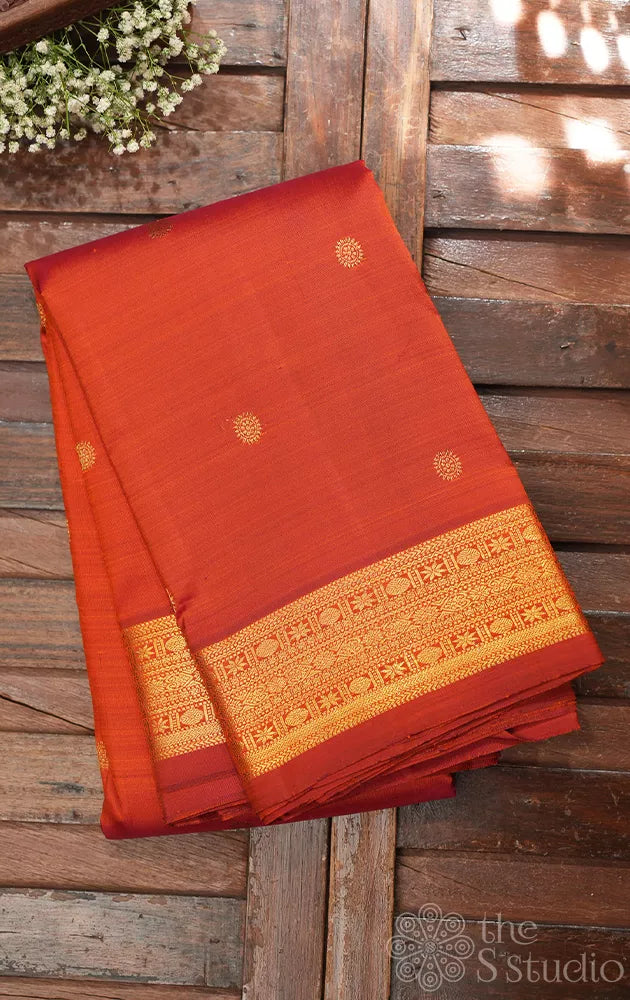 Rust kanchi silk saree with kamalam buttas and zari woven border