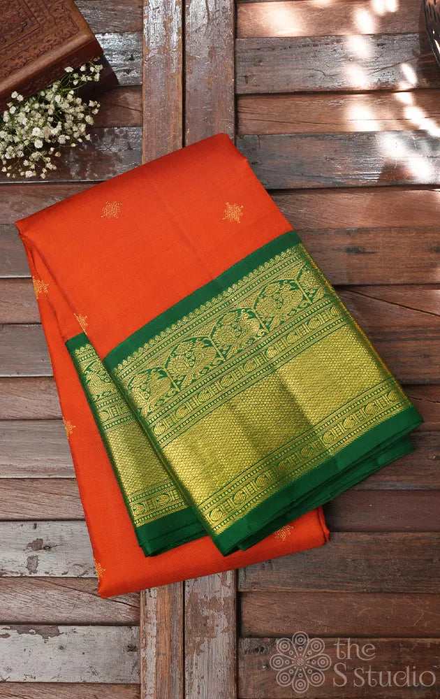 Rust orange kanchi pattu saree with korvai green zari border