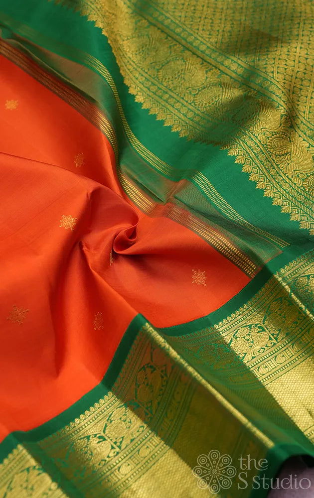 Rust orange kanchi pattu saree with korvai green zari border