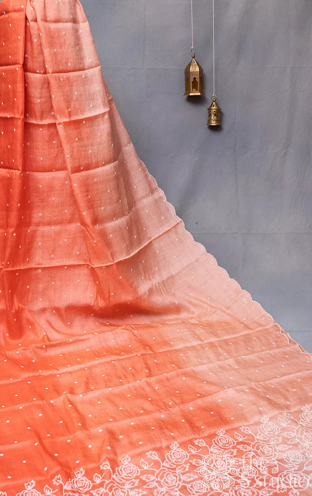 Peach shaded tussar silk saree with white floral embroidery and scallop border