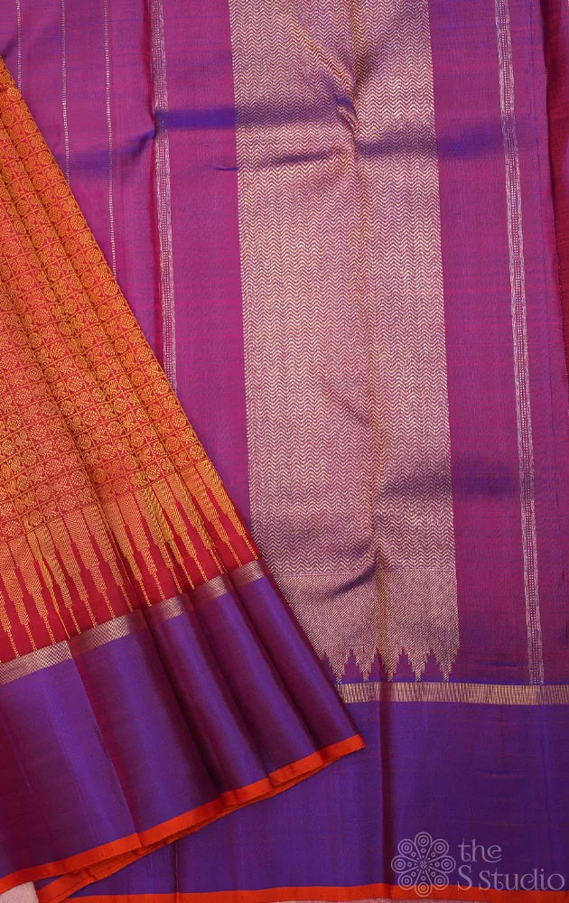 Reddish orange kanchi silk saree with a purple border