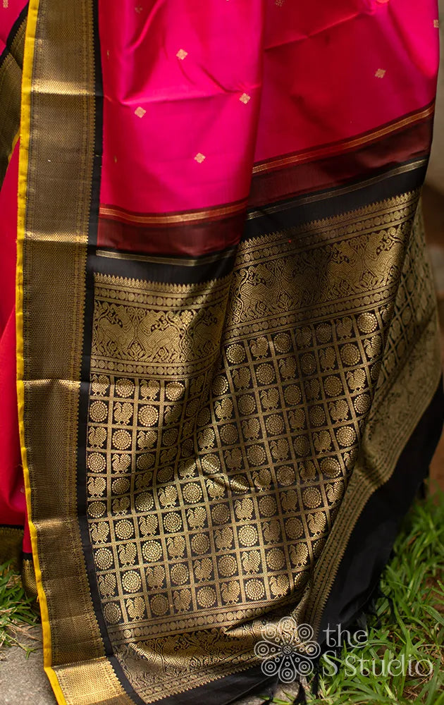 Bright pink kanchi silk saree with black korvai border
